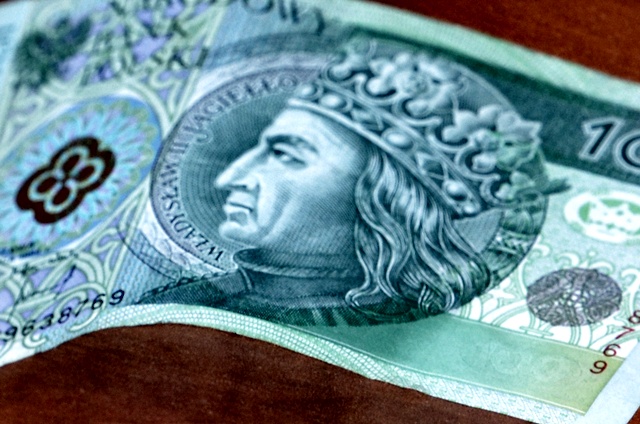 Banknot stuzłotowy z wizerunkiem króla Władysława II Jagiełły. W tle po jego obu stronach znajdują się stylizowane elementy ornamentyki gotyckiej.