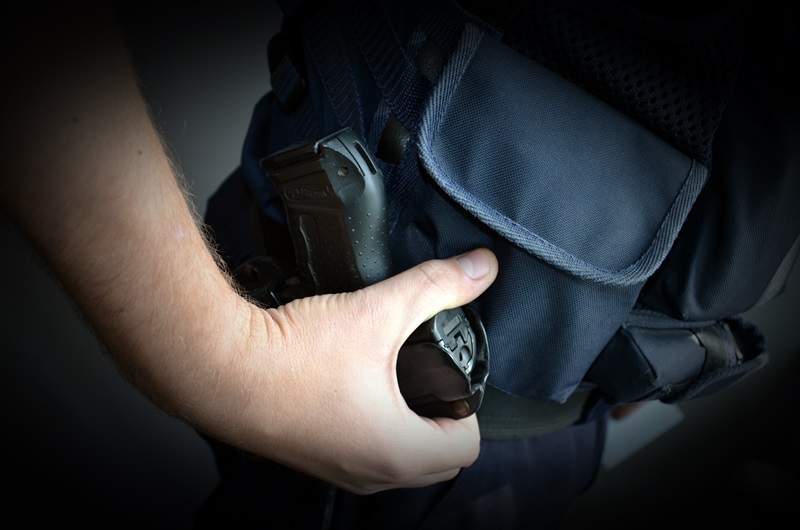 Policjant trzyma rękę na kaburze, w której jest broń