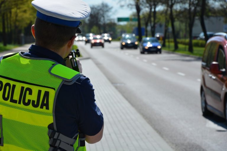 Policjant mierzy prędkość przy ruchliwej ulicy