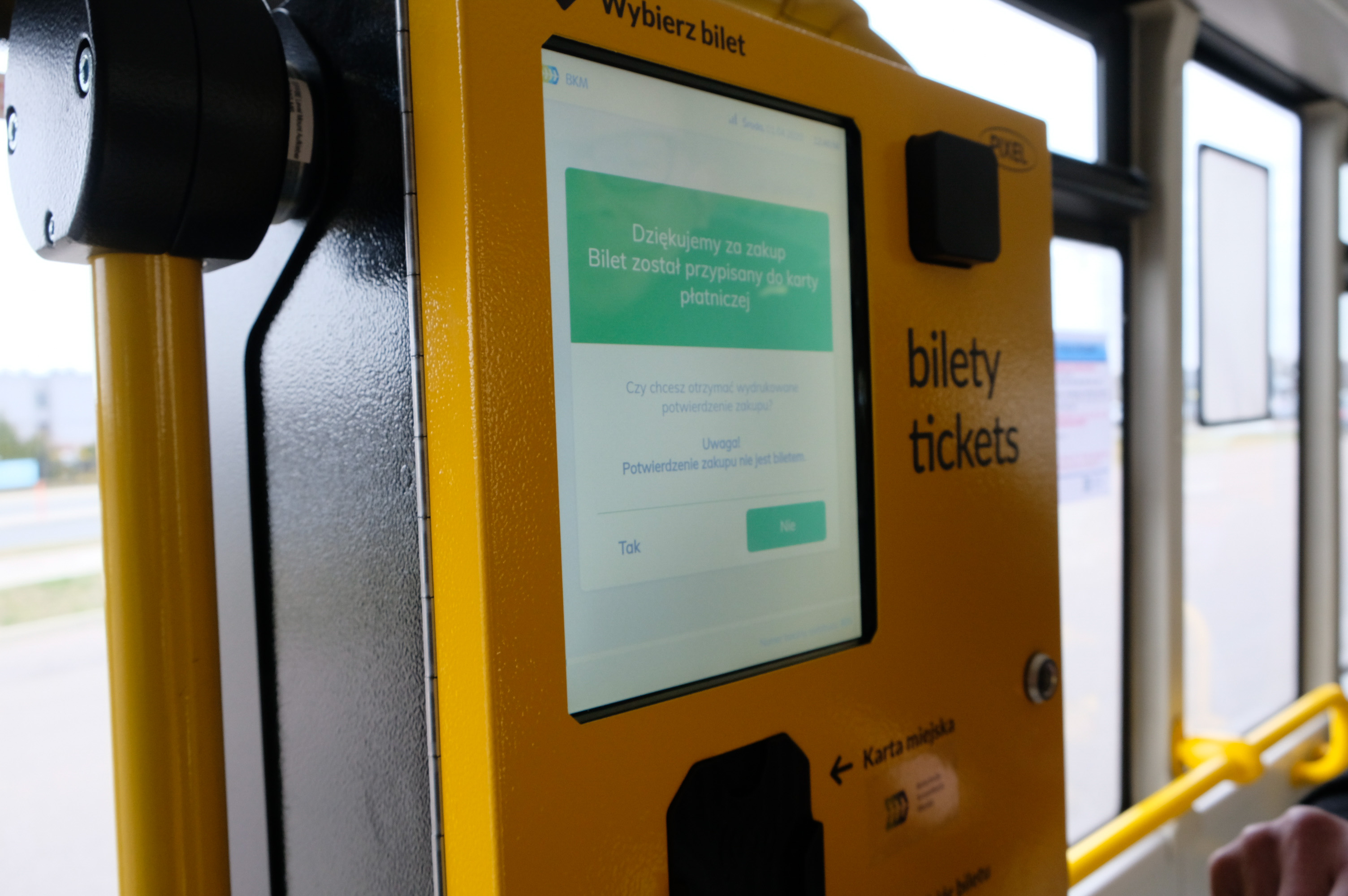 Żółty biletomat w autobusie komunikacji miejskiej