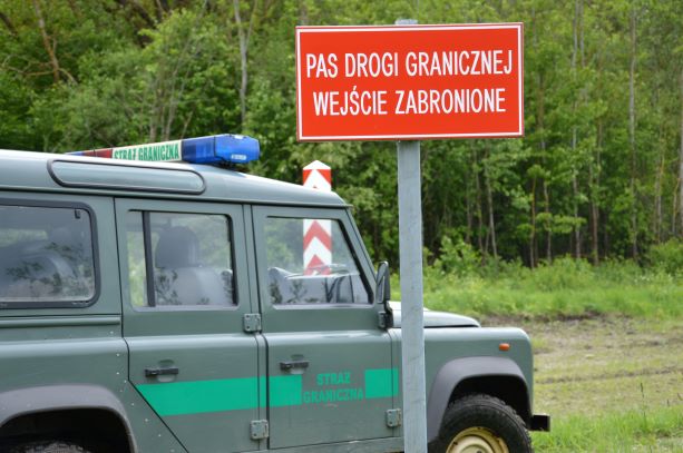 Samochód POSG stoi przy znaku granicy państwa