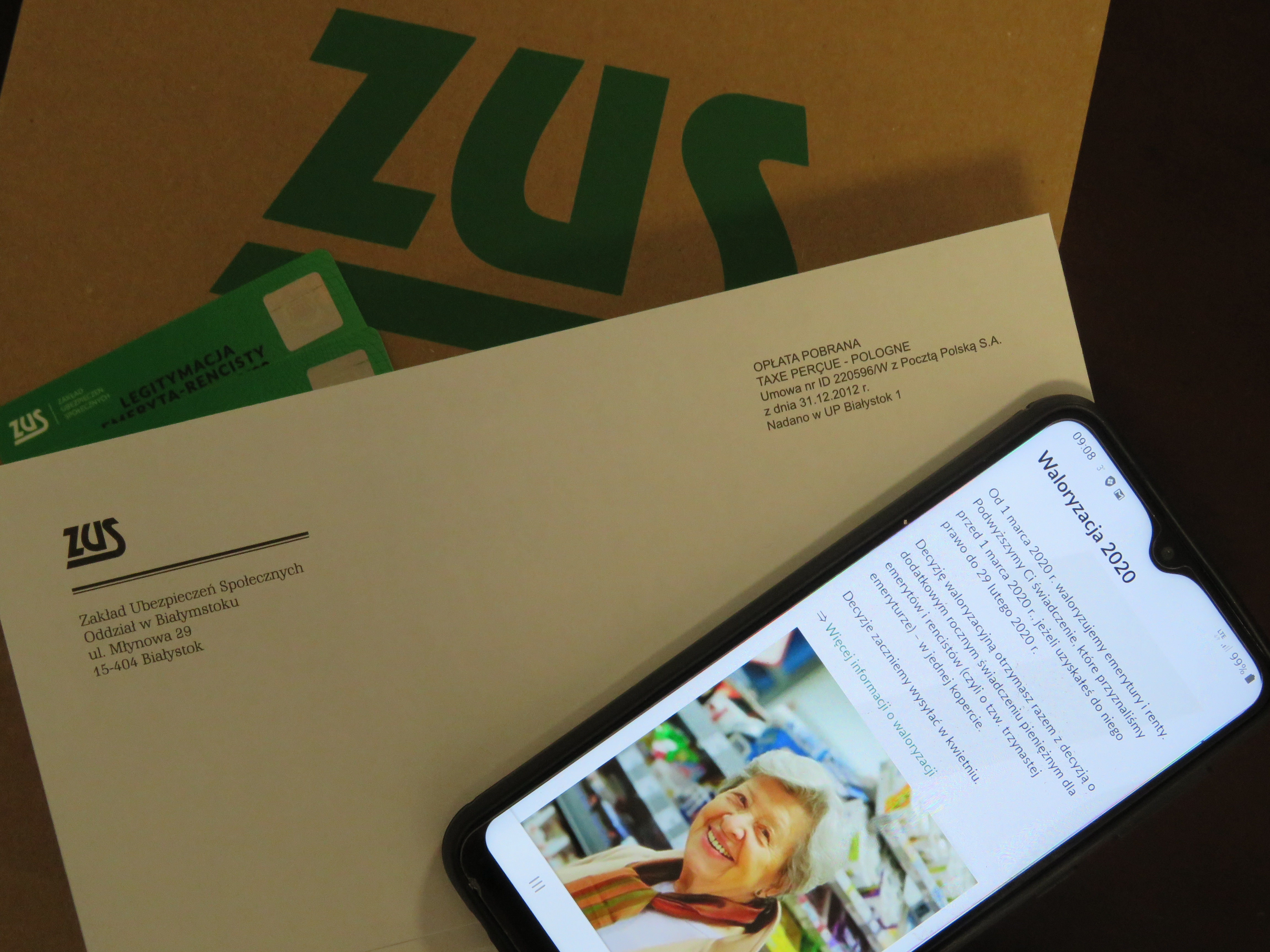 Włączony telefon leży na stercie dokumentów