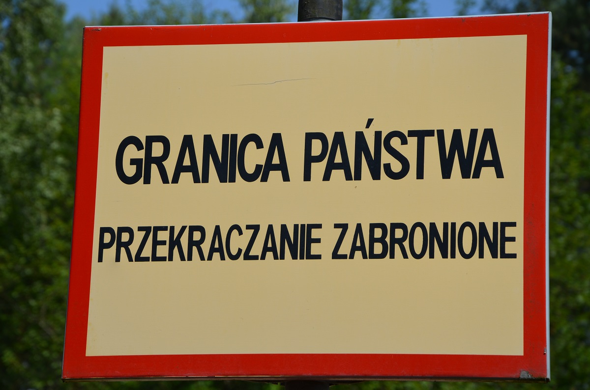 Żółta tabliczka z napisem granica państwa przekraczanie zabronione