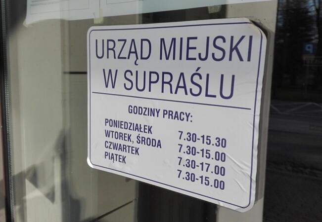 Tablica z napisem urząd miejski w supraślu na drzwiach do budynku magistratu