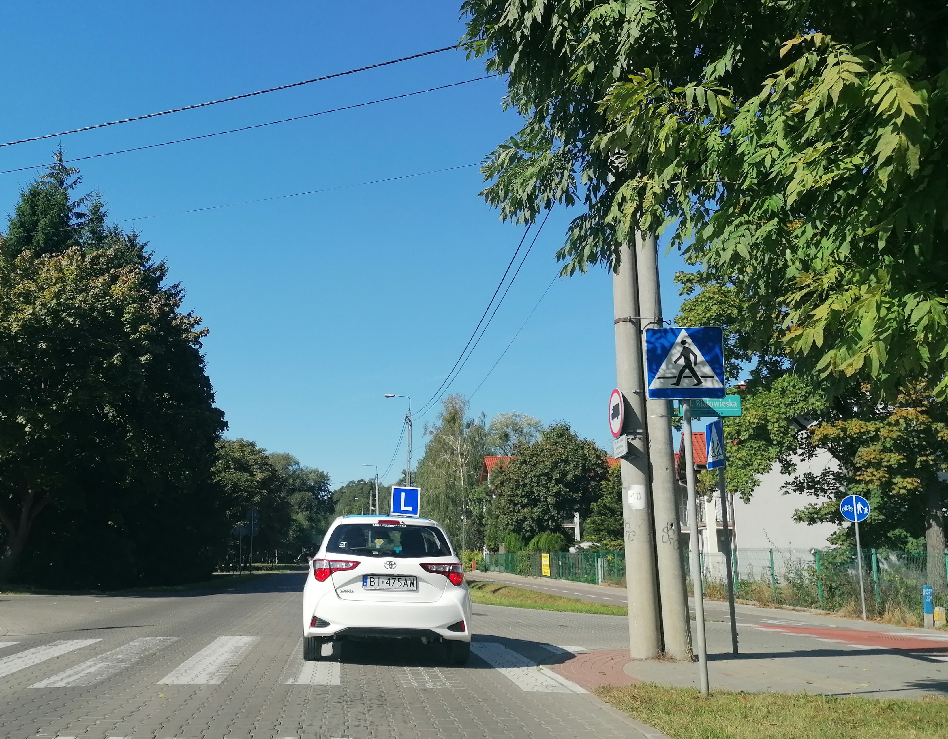 samochód do nauki jazdy jedzie przez ulicę Zwierzyniecką w Białymstoku.