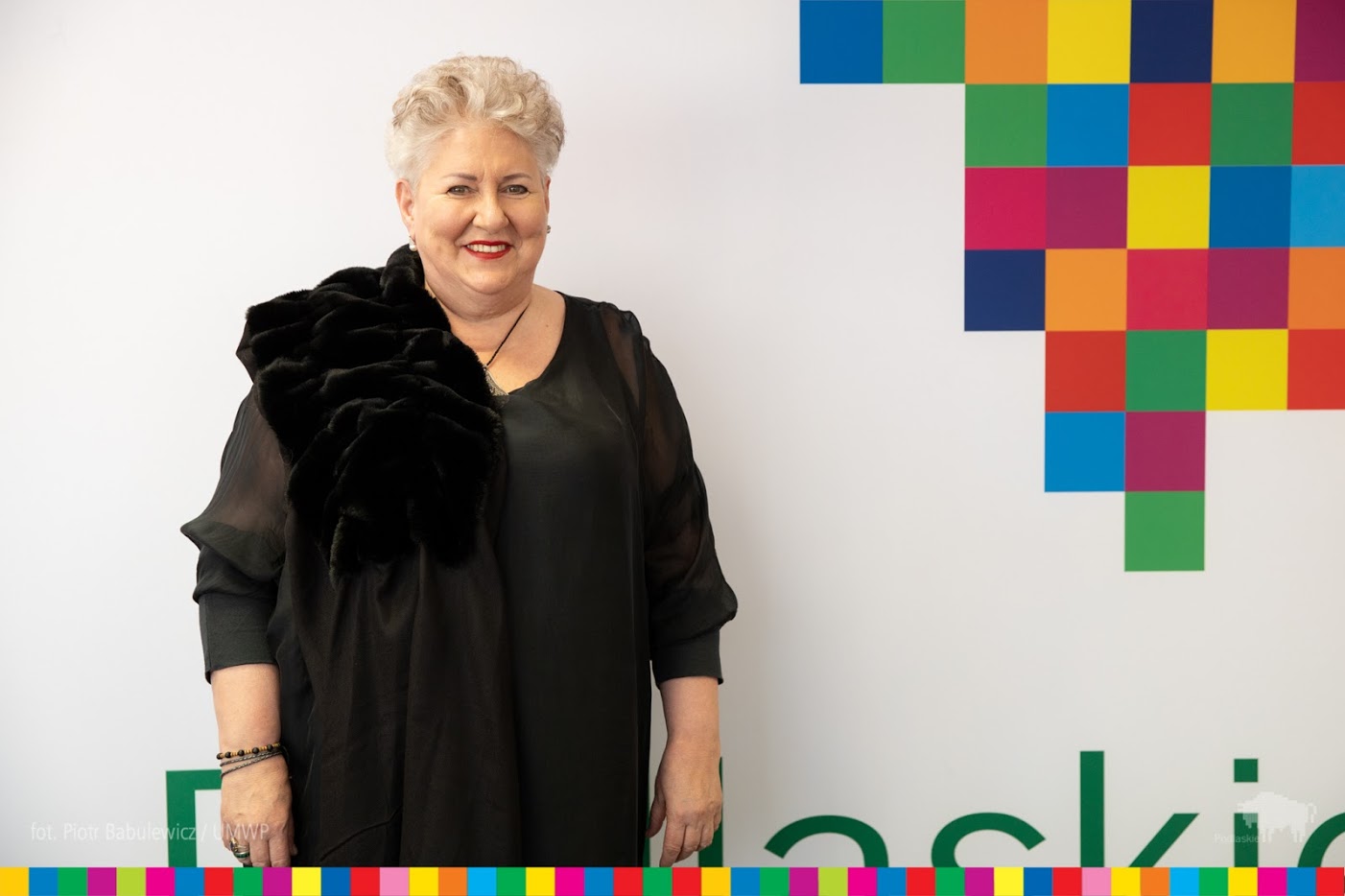 Prof. Violetta Bielcka na tle ściany z logo woj. podlaskiego