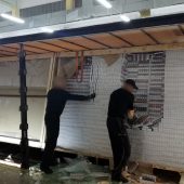 Funkcjonariusze KAS wyjmują papierosy z naczepy tira