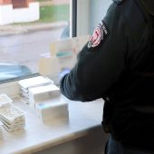 Funkcjonariusz KAS przy ułożonych na parapecie tabletkach i ampułkach