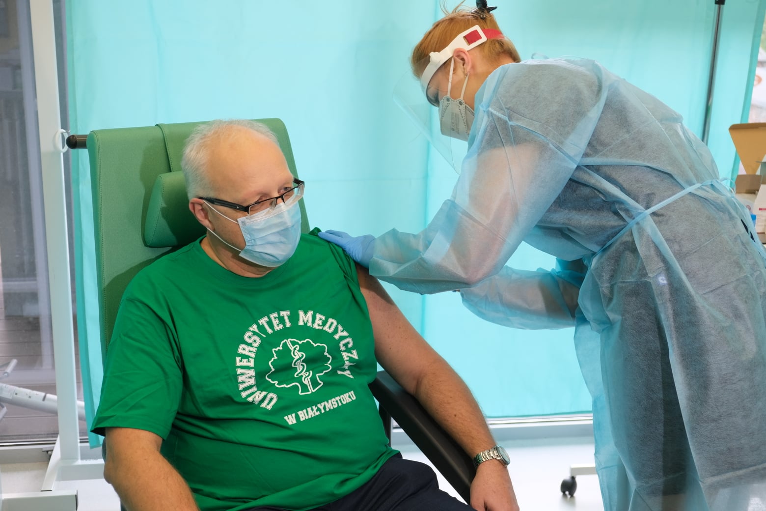 Pielęgniarka podaje mężczyźnie szczepionkę na COVID-19