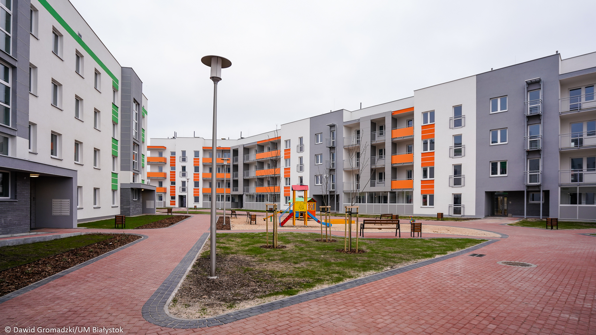 Osiedle bloków. Pomiędzy biało - szarymi - pomarańczowymi blok