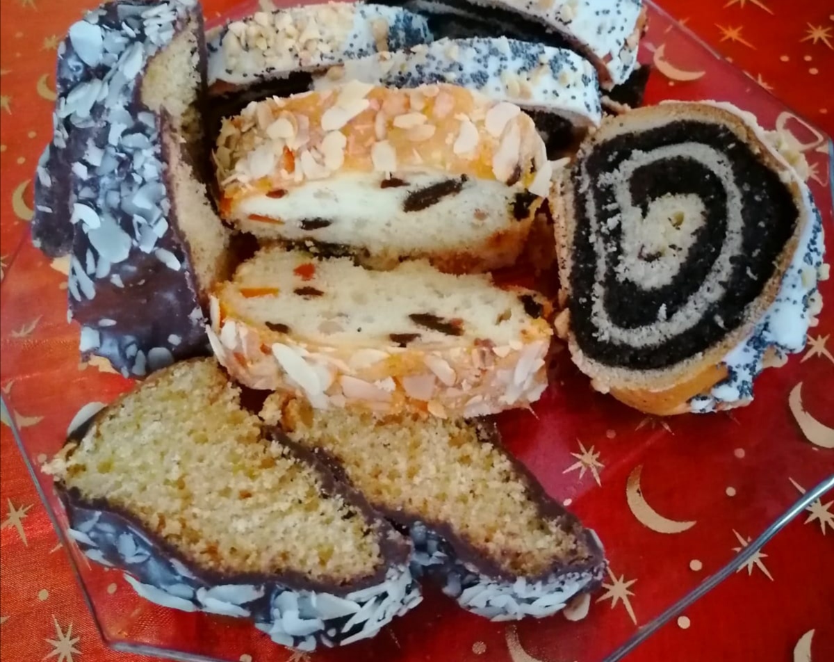 Na czerwonym obrusie leży ciasto; makowiec, keks