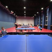 sala gimnastyczna, na której uczniowie grają w tenisa