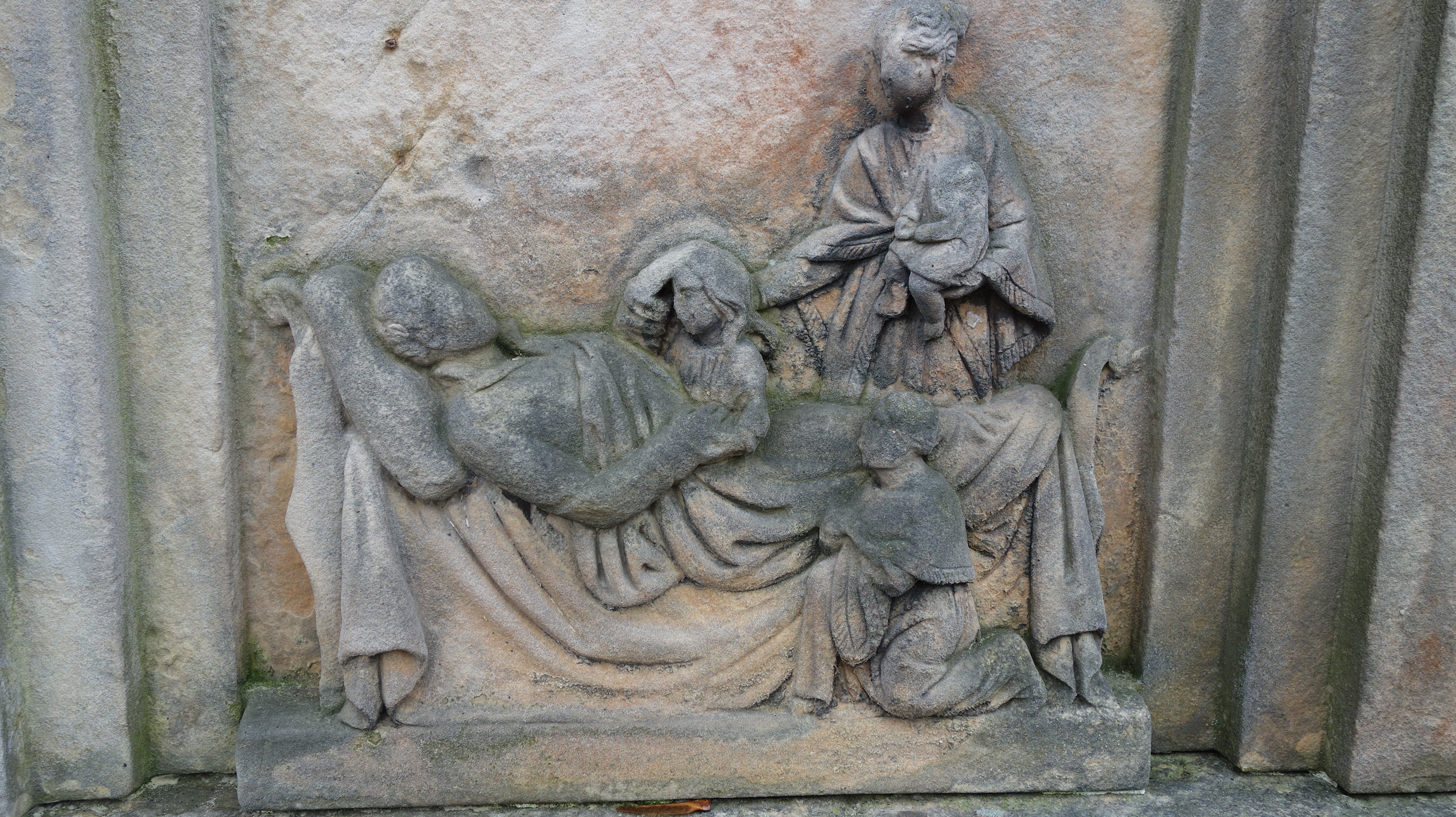 Fragment nagrobka z płaskorzeźbioną sceną ukazującą mężczyznę, zapewne na łożu śmierci, otoczonego dziećmi i kobietą trzymającą niemowlę