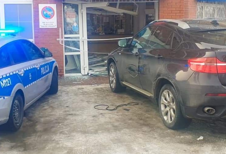 przed budynkiem poczty stoją dwa samochody