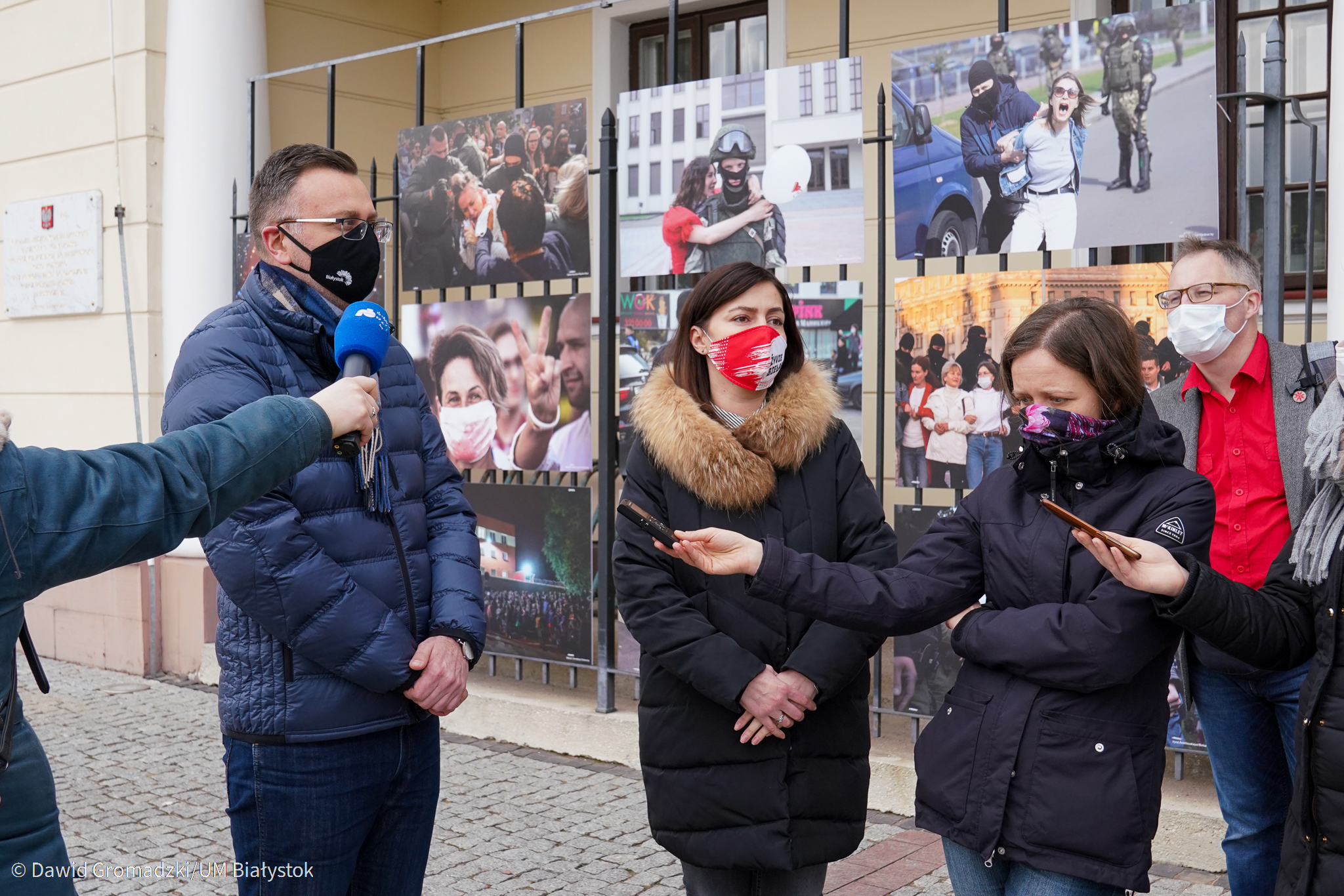Konferencja prasowa z udziałem zastępcy prezydenta, w tle zdjęcia z otwieranej wystawy