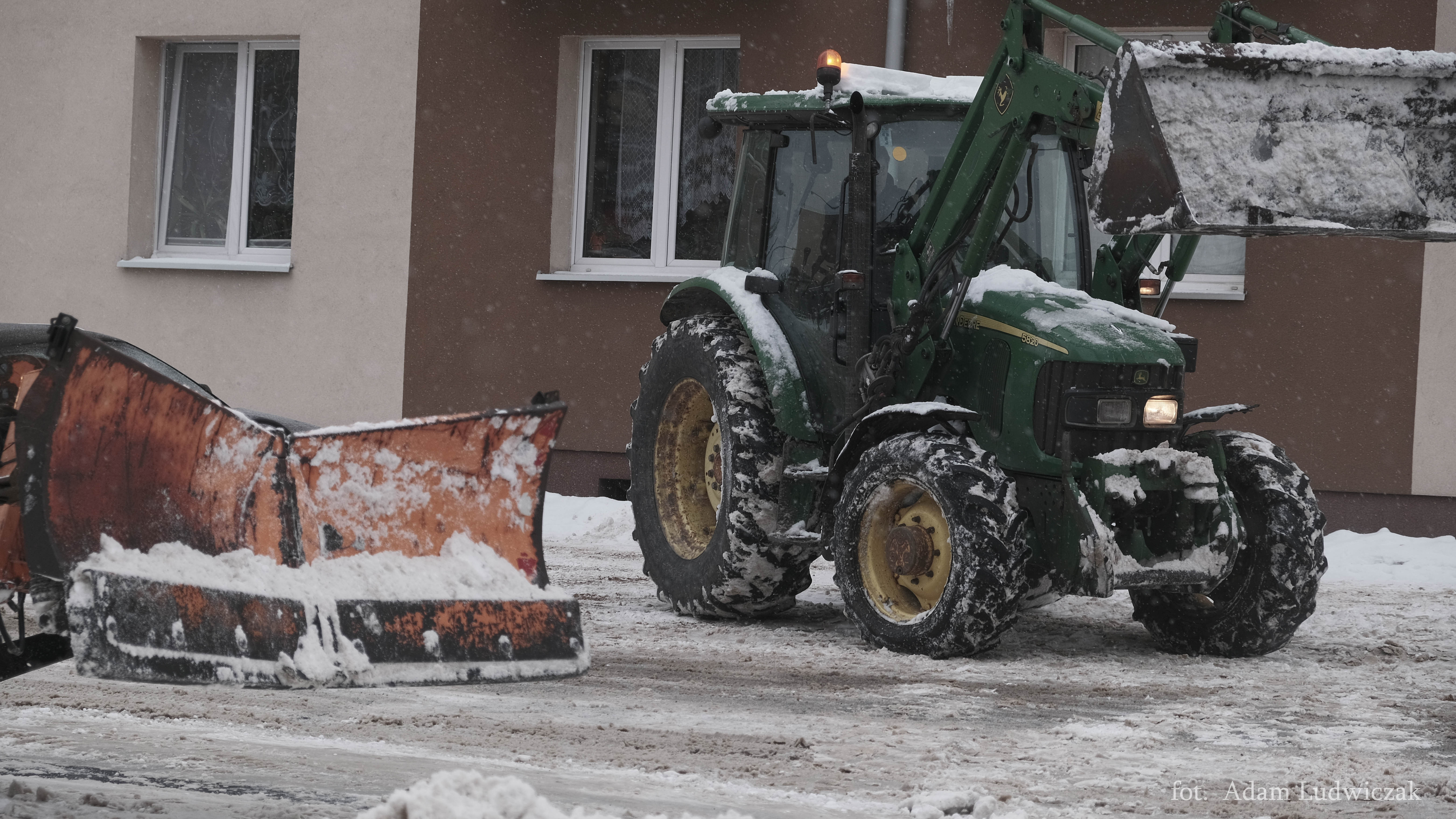 Traktor wyposażony w płóg odśnieża ulice