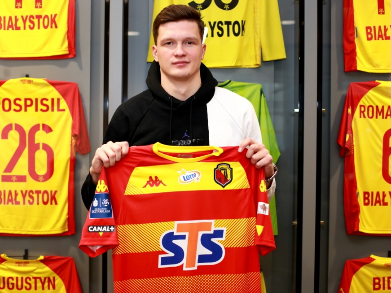 Mężczyzna trzyma w rękach klubową koszulkę Jagiellonii