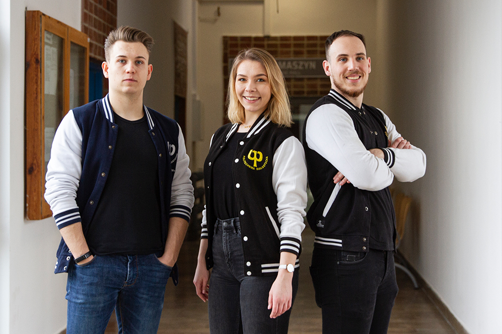 Studenci PB stoją w bluzach z logo uczelni