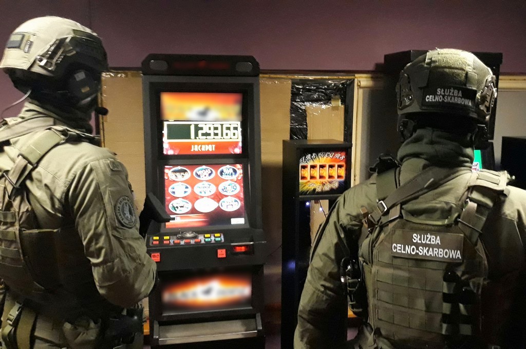 Funkcjonariusze KAS stoją przy automatach do gier