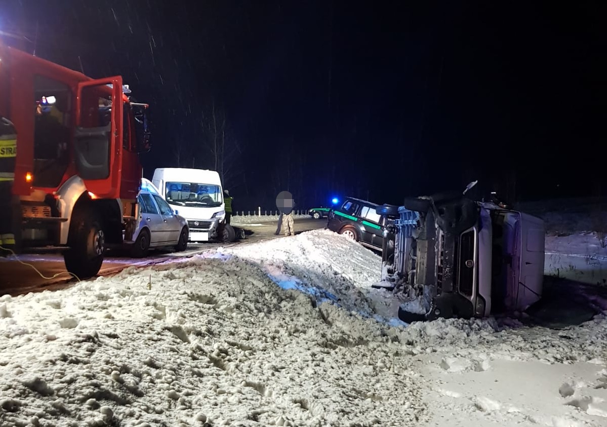 Ulica, na której stoją auta, dwa z nich są w rowie