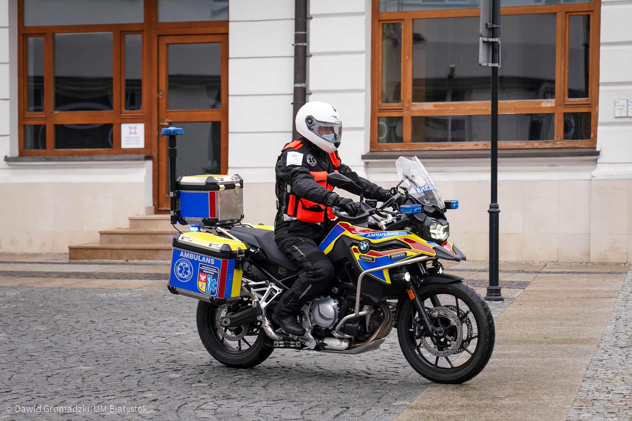 Człowiek w kasku i w specjalnym motocyklowym kombinezonie siedzi na motocyklu