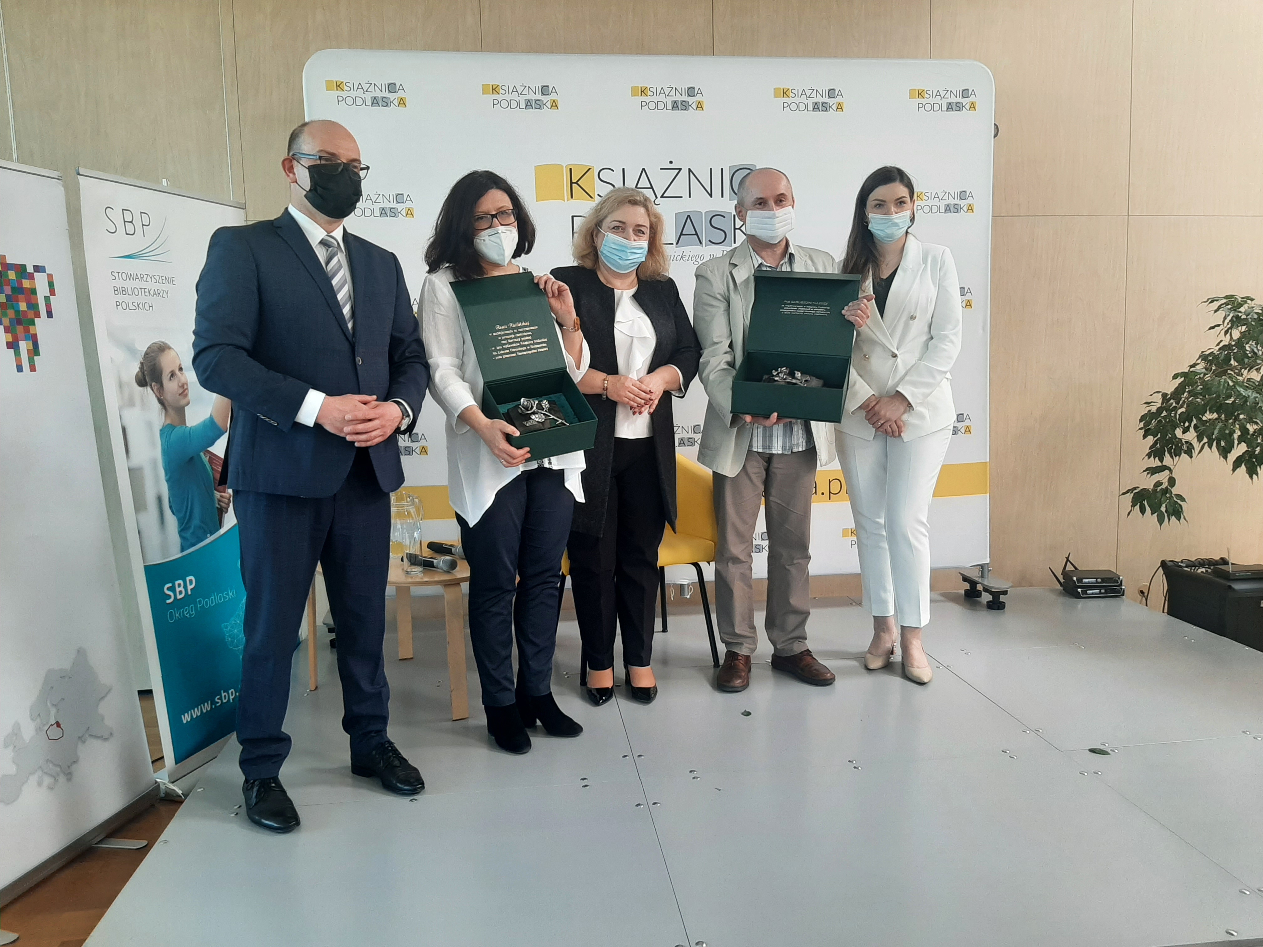 Na ściance Książnicy Podlaskiej pięć osób. Od lewej marszałek,laureatka Anna Kietlińska, dyrektor Książnicy Beata Zadykowicz, laureat Dariusz Kulesza i dyrektor departamentu kultury urzędu marszałkowskiegi