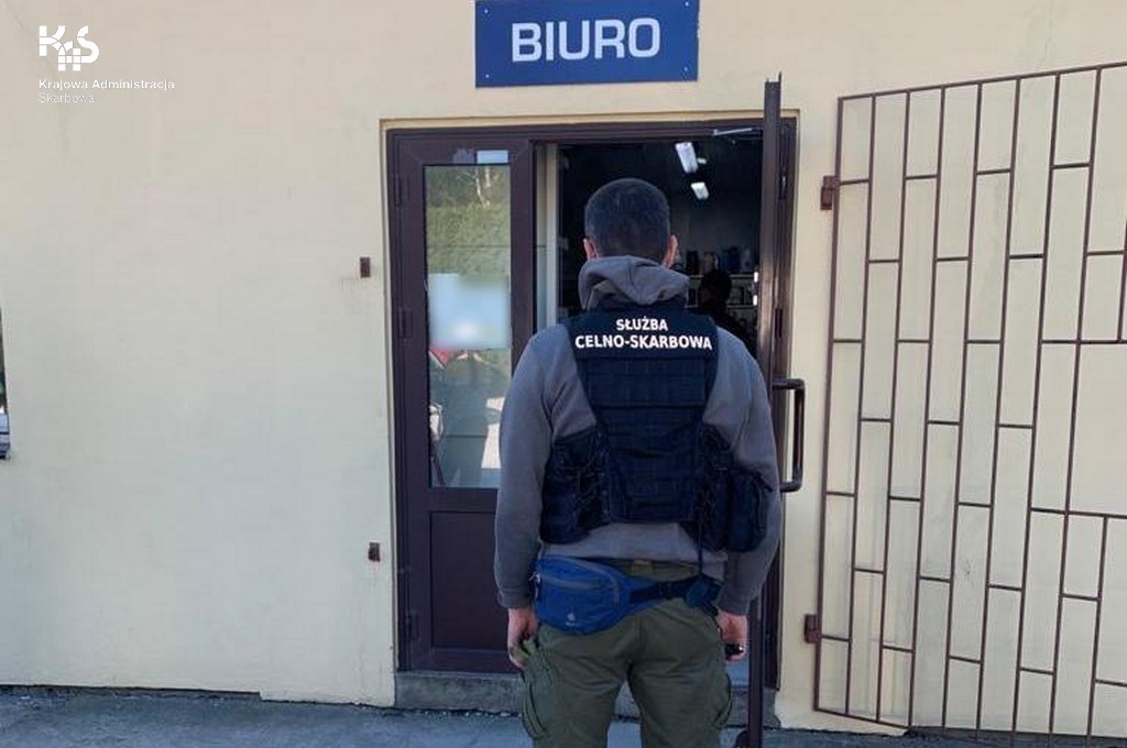 Funckjonariusz KAS przed wejściem do budynku