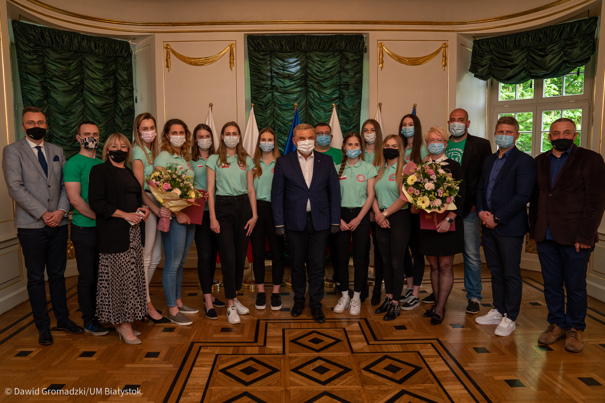 Drużyna siatkarek stoi w rzędzie, przed nimi jest prezydent Białegostoku