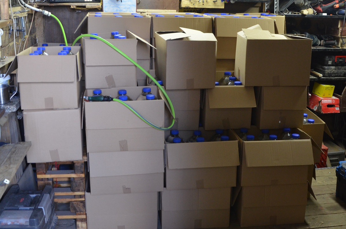 Plastikowe butelki z nielegalnym alkoholem w kartonowych pudłach