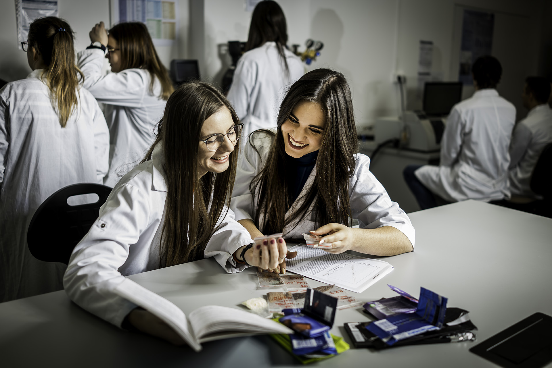 Studentki siedzą przy biurku w laboratorium