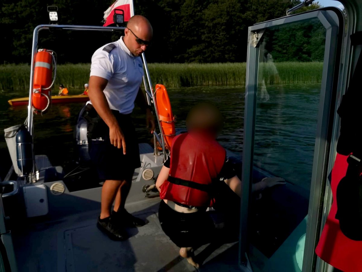 Policjant z dziewczynką na łodzi policyjnej