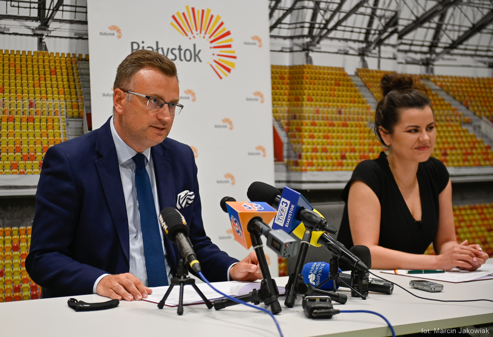Konferencja prasowa z udziałem wiceprezydenta i prezeski Jagiellonii, oboje siedzą przy stole zastawionym mikrofonami
