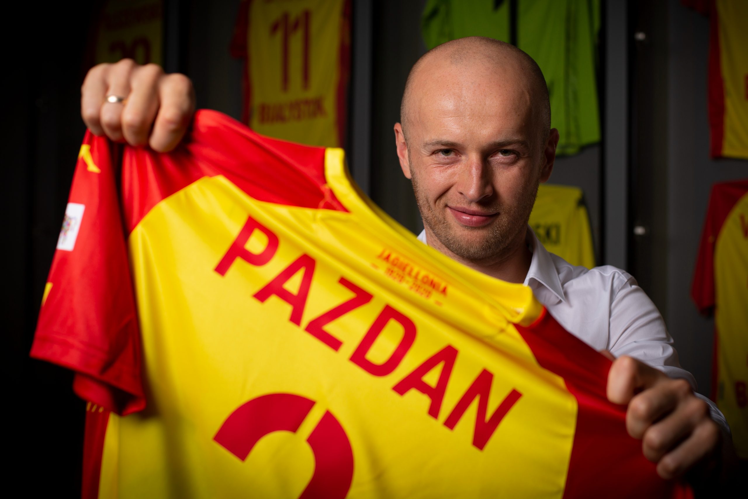 Michał Pazdan trzyma żółto - czerwoną koszulkę z numerem 2