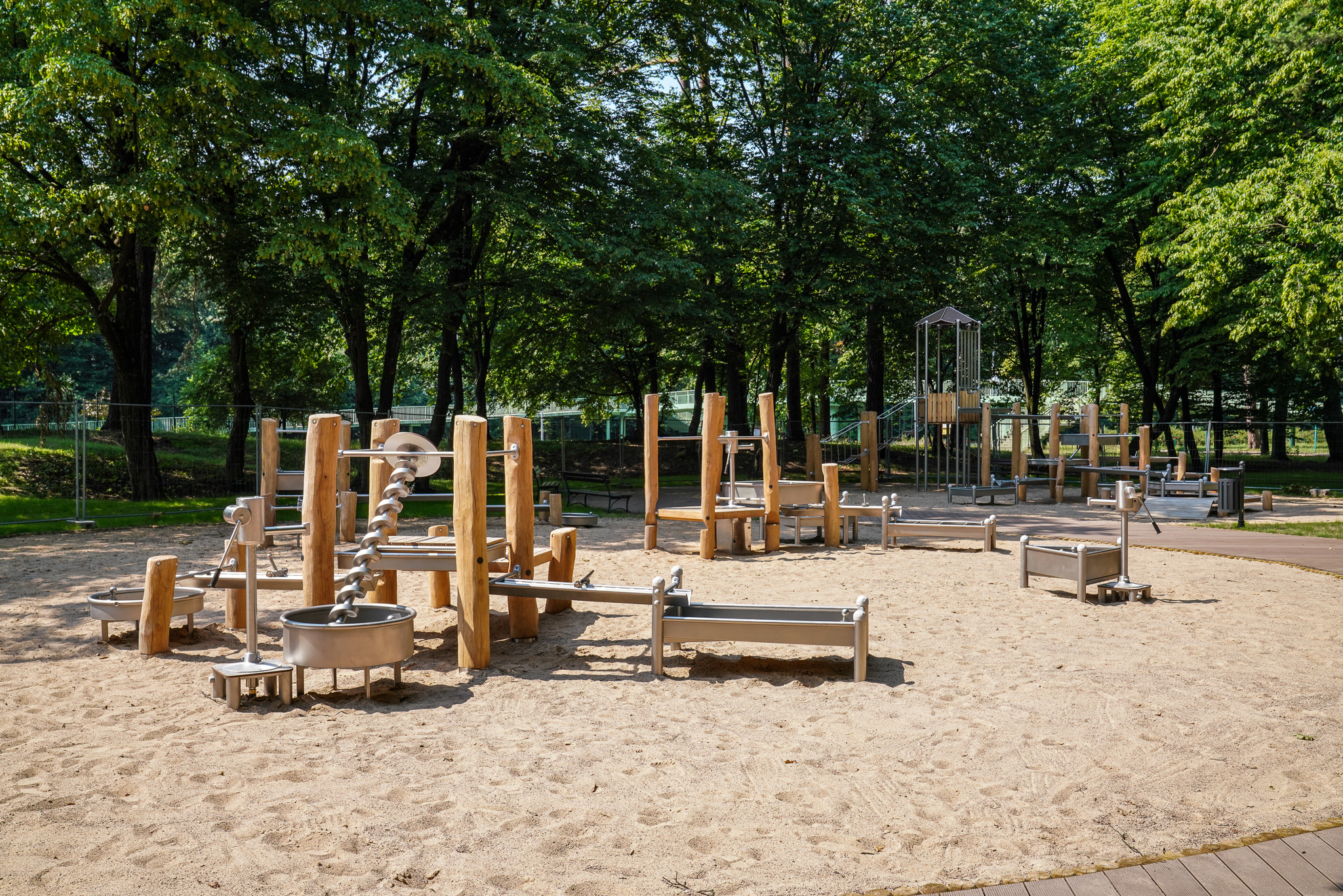Plac zabaw, z piaskowym podłożem i drewnianymi zabawkami