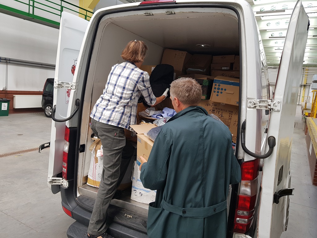 Kobieta i mężczyzna umieszczają w busie transport ubrań