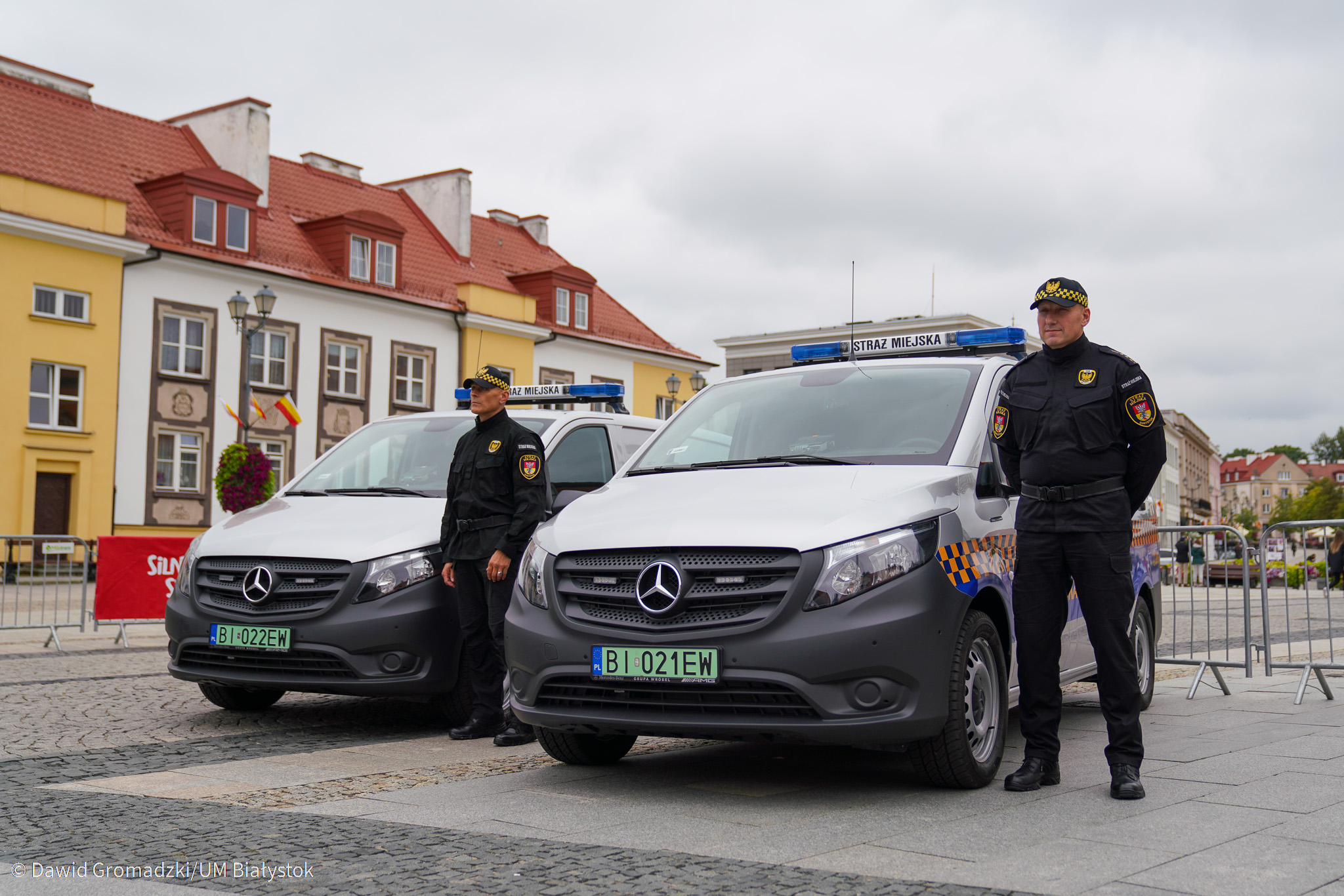 Dwaj strażnicy miejscy stoją przy nowych pojazdach elektrycznych