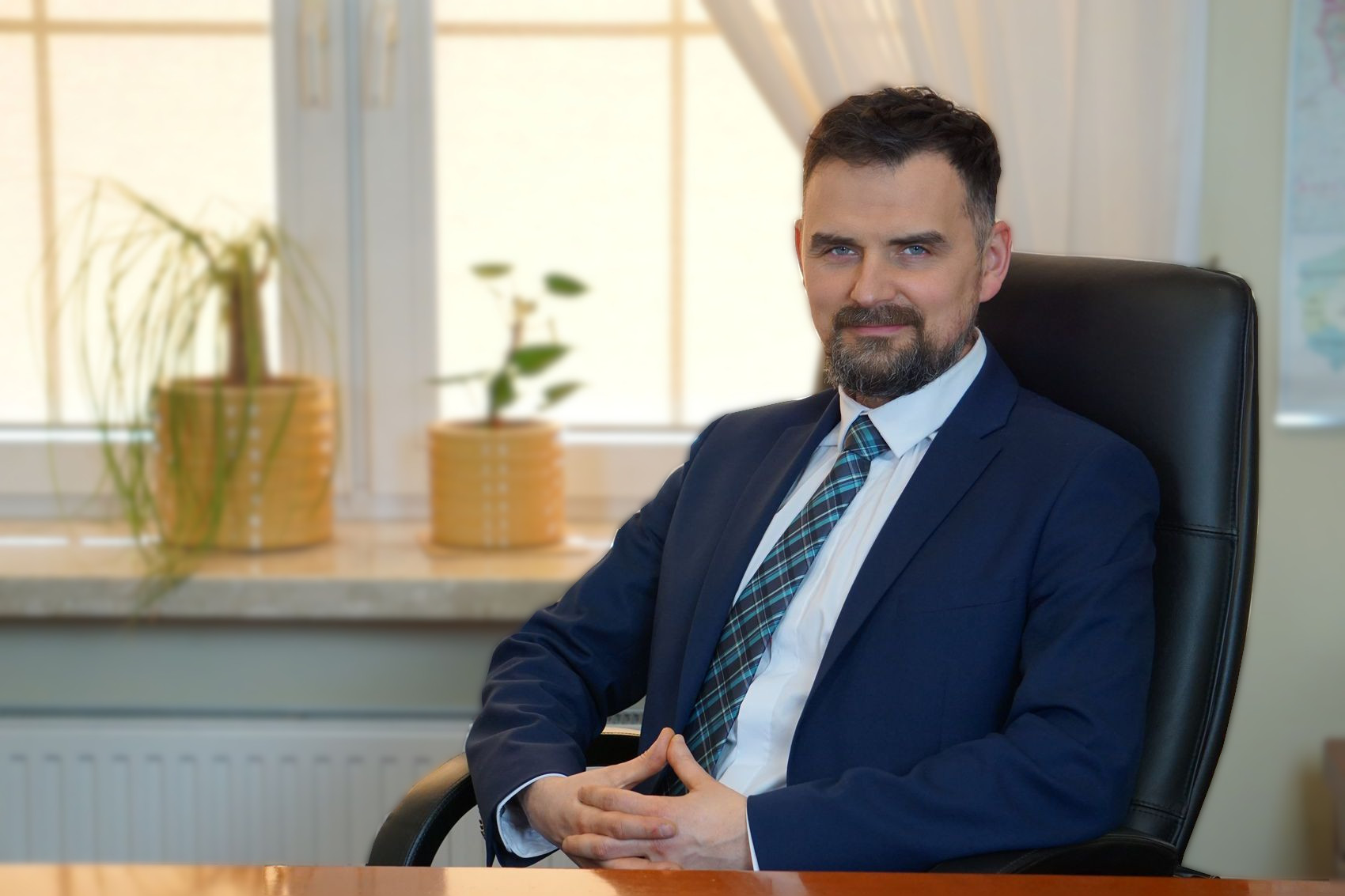 Mężczyzna siedzi w fotelu, przy biurku