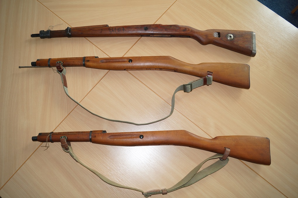 Na stole leżą dwie łoże od karabinu Mosin i jedno od karabinu Mauser 98k