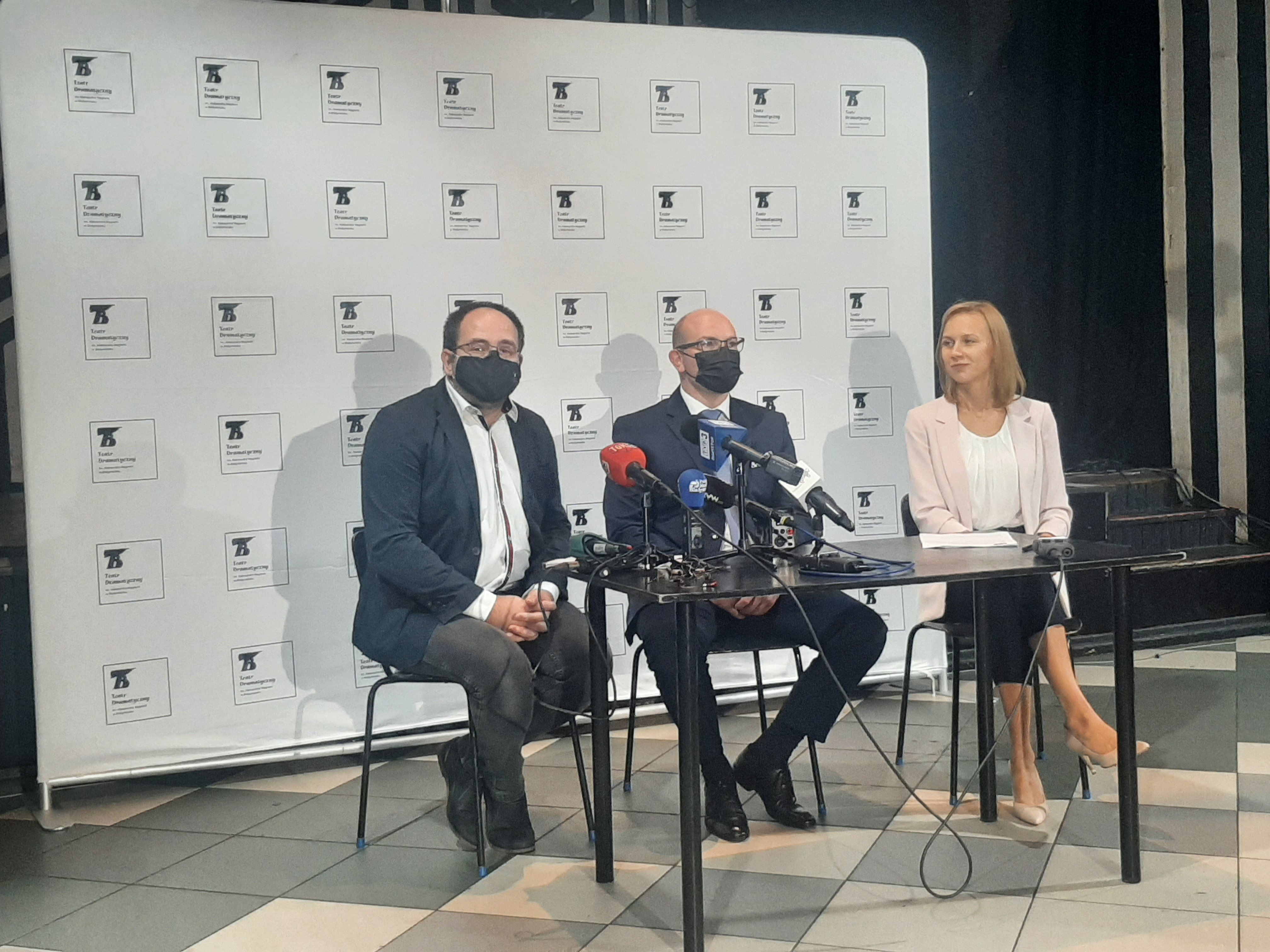 Na ściance Teatru Dramatycznego, przy stoliku siedzą trzy osoby; od lewej strony dyrektor instytucji, po środku marszałek, z prawej zastępczyni dyrektora Teatru Dramatycznego. Przed mówiącymi stoją mikrofony redakcji