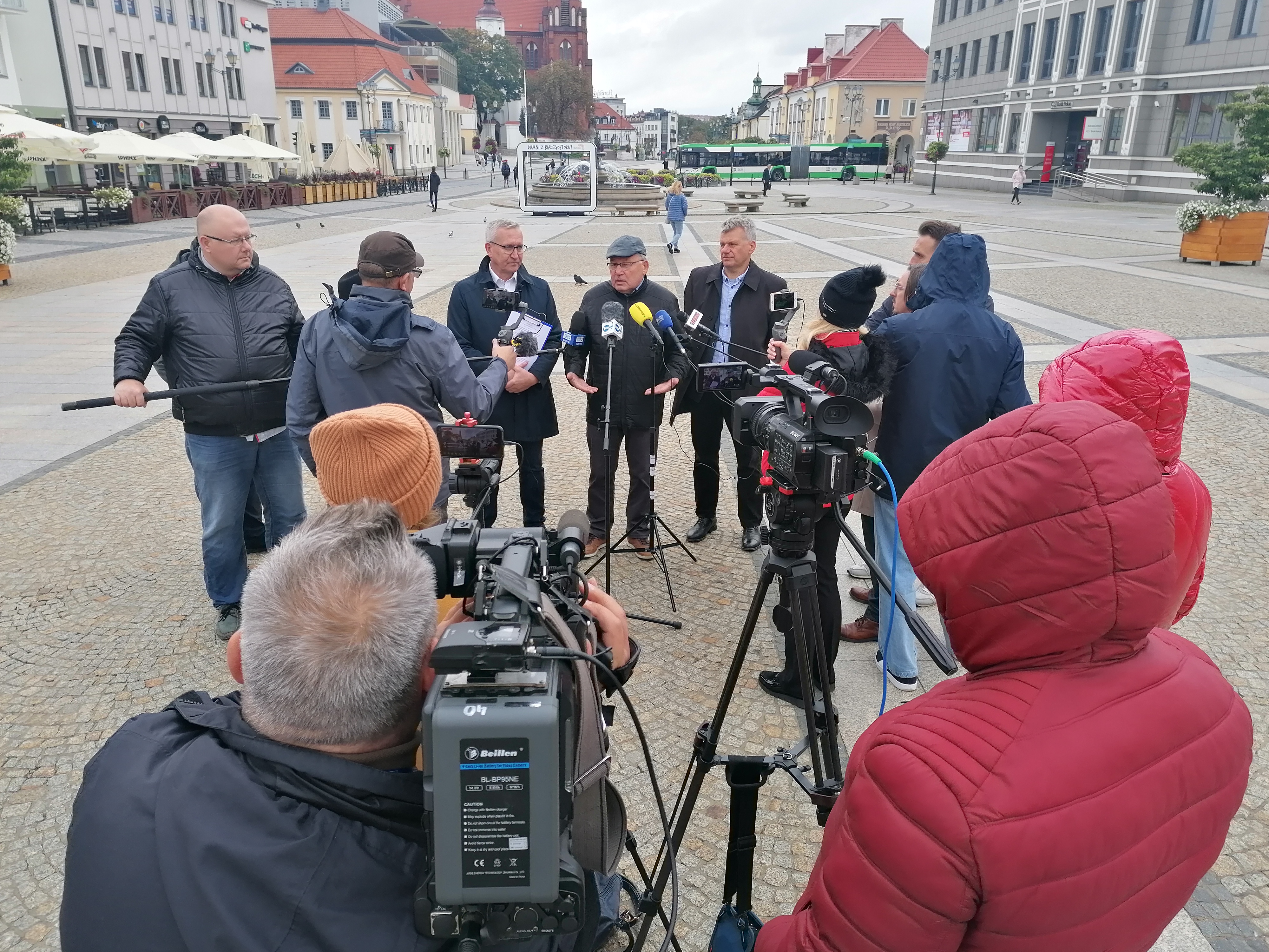 Konferencja prasowa na Rynku Kościuszki. Stoi grupa dziennikarzy trzymających mikrofony. Przemawiają przedsiębiorcy i polityk
