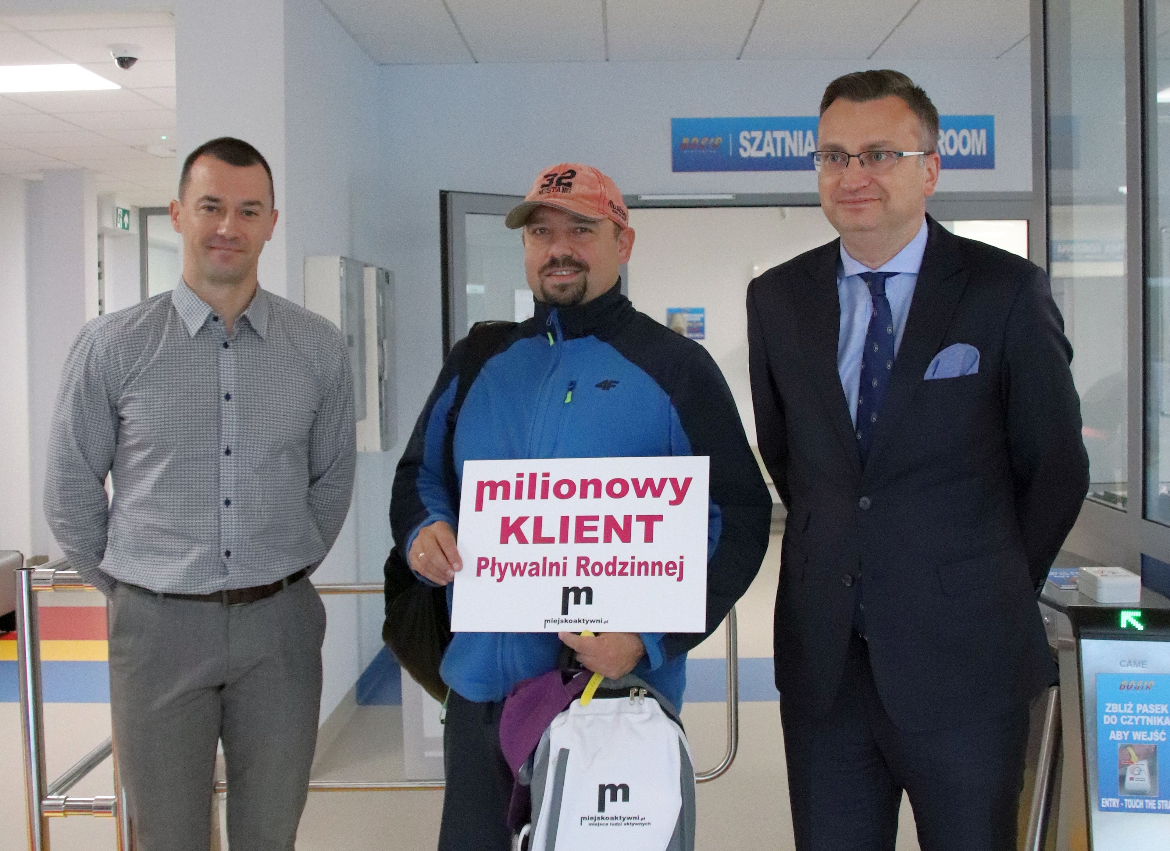 Trzech mężczyzn stoi przed wejściem na pływalnię
