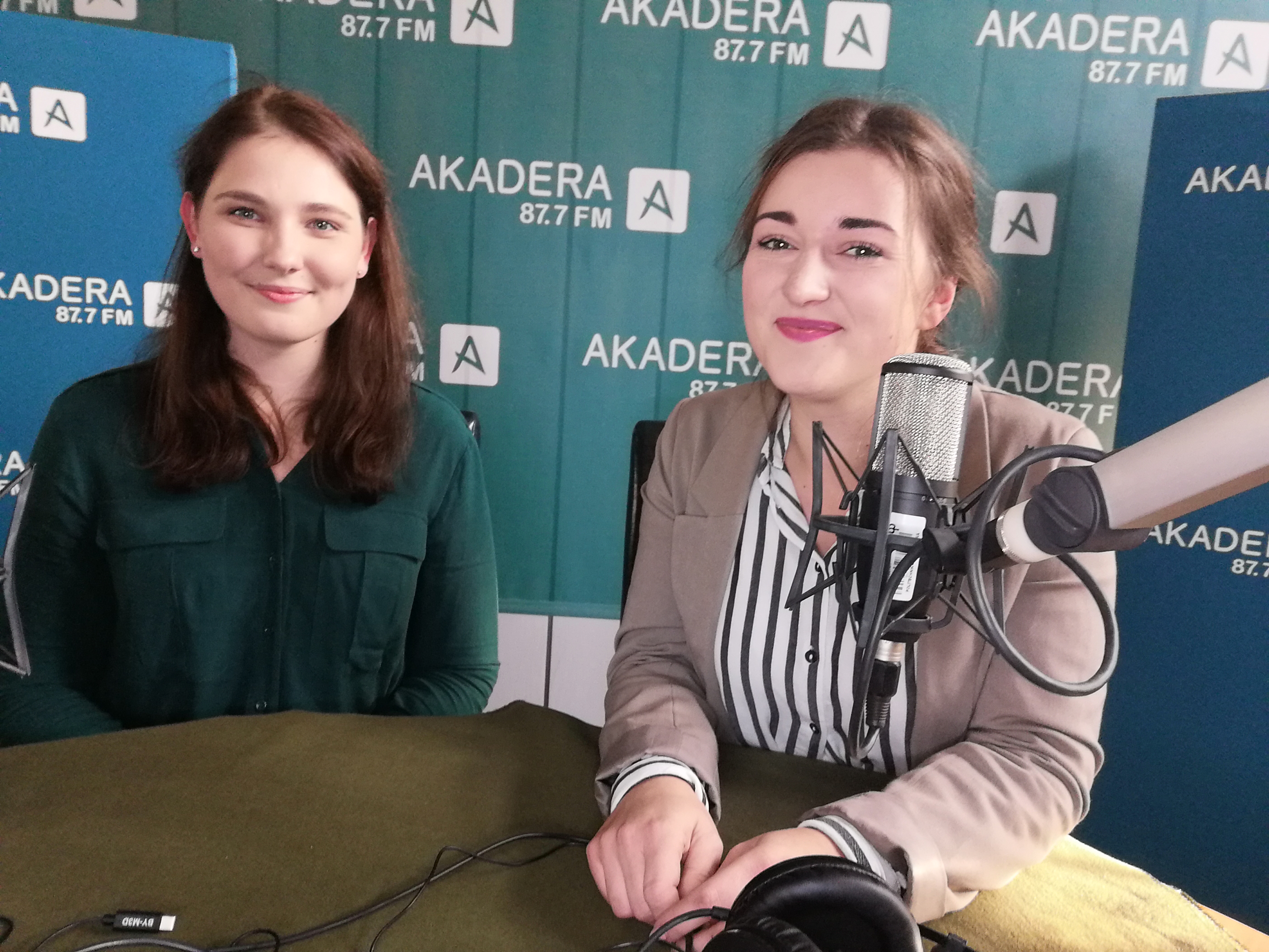 Dwie dziewczyny siedzą przy stole w radiowym stidio