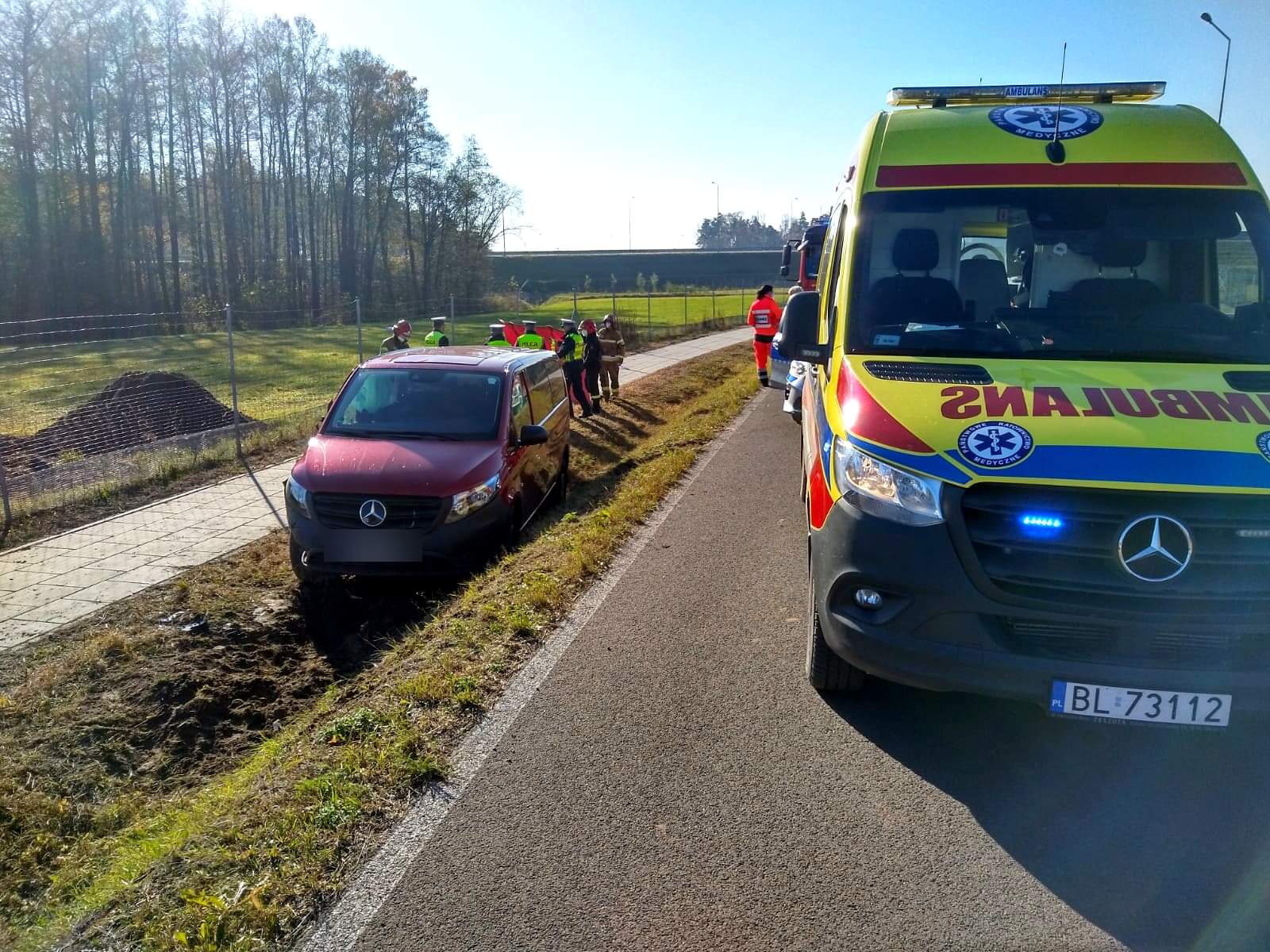 Na drodze stoi karetka, w rowie stoi auto