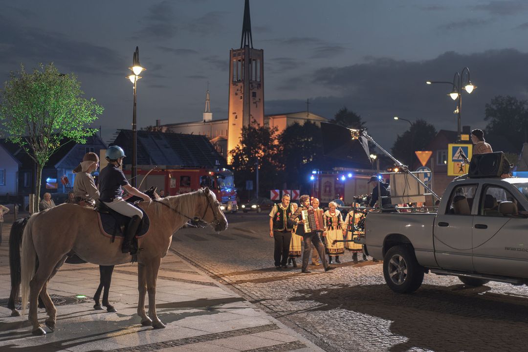 Ulica miasta, po której spaceruje mężczyzna z akordeonem
