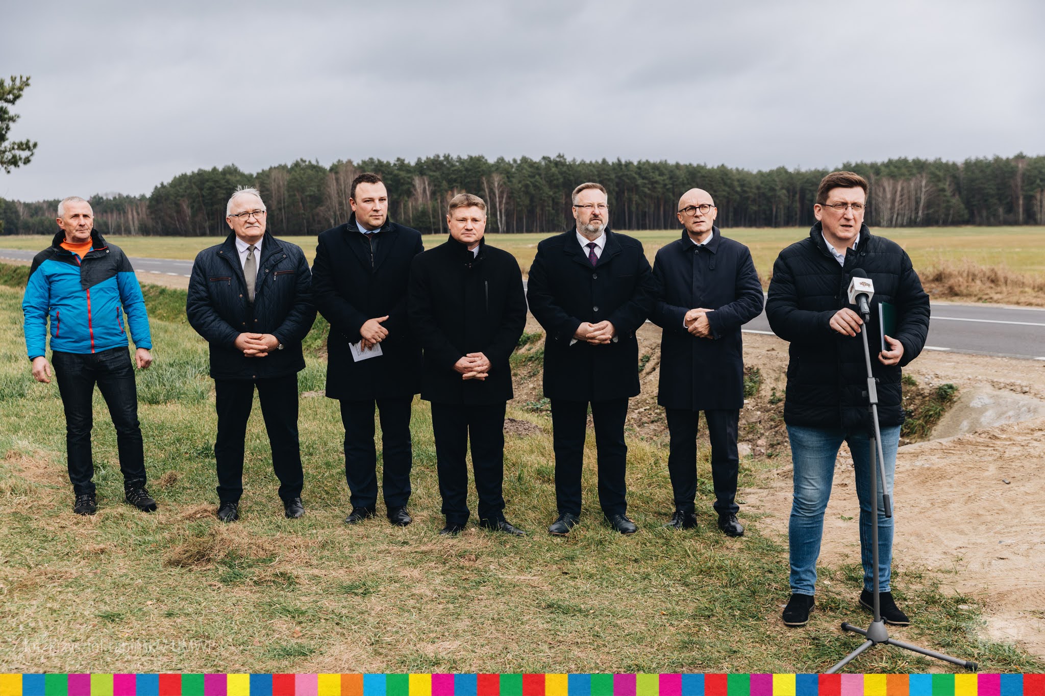 Siedmiu mężczyzn stoi przy drodze