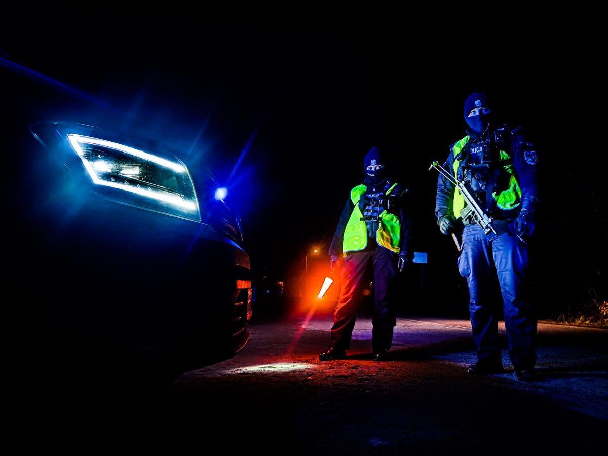 Policjanci stoją przy radiowozie