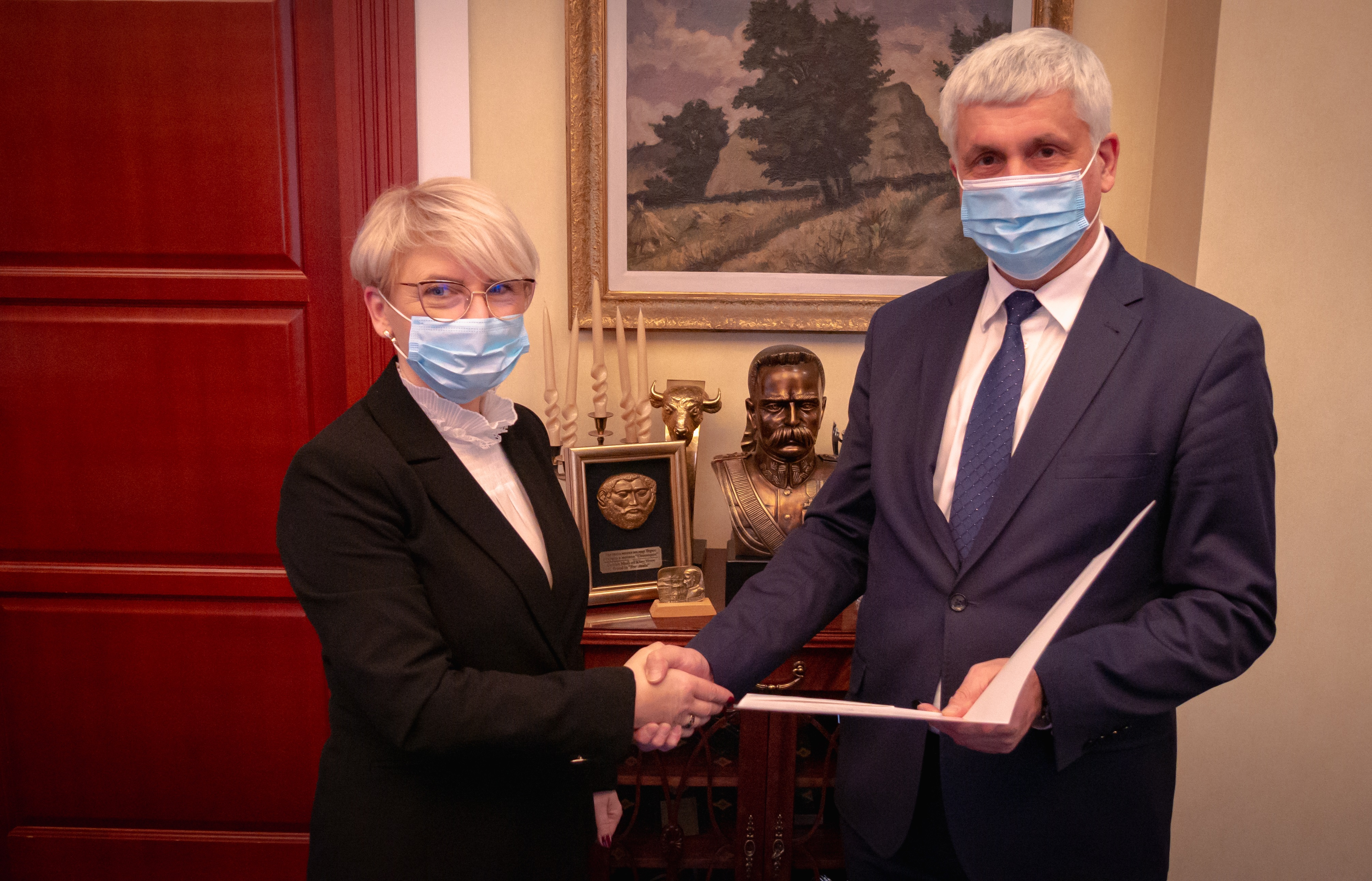 Mężczyzna ściska dłoń kobiecie w ramach gratulacji