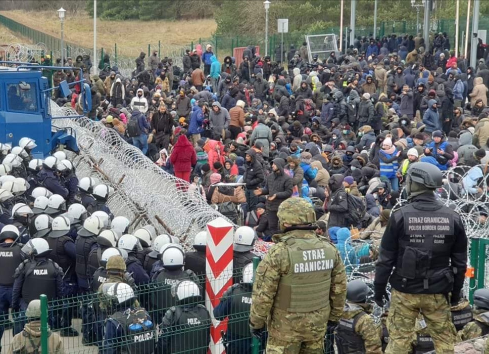 Przejście graniczne rozdzielone drutem kolczastym, po białoruskiej stronie migranci, po polskiej - wojsko i policja