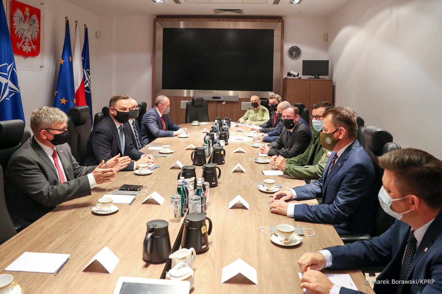 Mężczyźni siedzą przy podłużnym stole