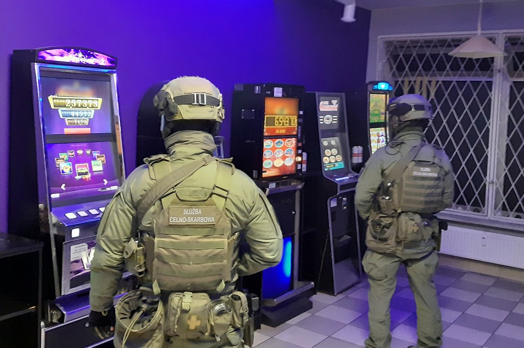 Uzbrojeni funkcjonariusze KAS wewnątrz nielegalnego salonu z automatami do gier hazardowych